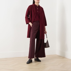 Model wearing Max Mara S red cotton silk cashmere knit, styled with burgundy wide-leg trousers, longline coat, and black loafers.