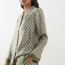 Model wearing Max Mara S Dice Silk Pyjama Shirt in Kaki Dice, featuring archival dice print, Cuban collar, styled with matching trousers.