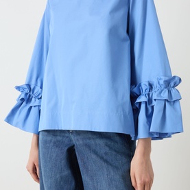 Model wearing Max Mara S light blue cotton shirt with flared sleeves and double ruffle cuff detail, styled with dark denim jeans.
