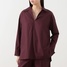 Model wearing burgundy long-sleeve popover shirt with open collar, styled with matching wide-leg trousers