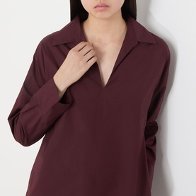 Model wearing burgundy long-sleeve V-neck blouse with open collar, relaxed silhouette and dropped shoulders