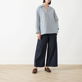 Model wearing Max Mara S Cristel Striped Shirt in dark green cotton with wide-leg navy trousers and brown loafers