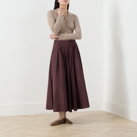 Model wearing Max Mara S Romina Flared Skirt in red, midi length with gathered waist, styled with a beige knit top and flat mules
