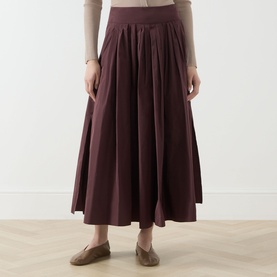 Model wearing Max Mara S Romina Flared Skirt in red, midi length with gathered waist and side pockets, styled with loafers.