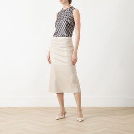Model wearing Max Mara S beige cotton midi skirt with wrap-style front, styled with a monochrome sleeveless top and cream heels.