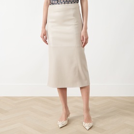 Model wearing Max Mara S beige cotton midi skirt with a black patterned top and white pointed-toe heels.