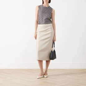Model wearing Max Mara S beige cotton midi pencil skirt, styled with monochrome print top, black mini bag and cream pointed flats.