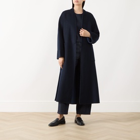 Model wearing Max Mara S ultramarine longline coat styled with dark cropped trousers and black loafers.
