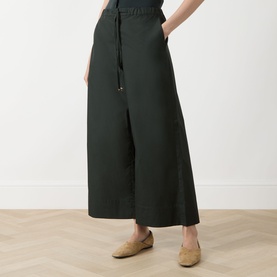 Model wearing Max Mara S green wide-leg cotton trousers with drawstring waist, styled with tan flat shoes