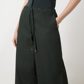 Model wearing Max Mara S green cotton wide-leg trousers with drawstring waist and front pockets, styled with a dark top