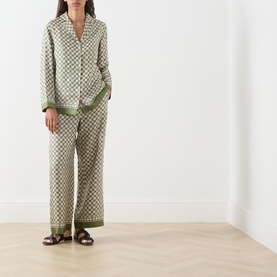 Model wearing Max Mara S Kaki Dice silk trousers with matching printed shirt and brown sandals.