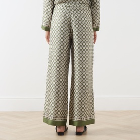 Model wearing Max Mara S Kaki Dice silk wide-leg trousers with geometric print and contrast border hem, styled with matching top.