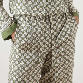 Model wearing Max Mara S Kaki Dice silk trousers with geometric print, shown with matching printed shirt, hands in pockets.