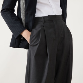 Model wearing Max Mara S Taro High-Waisted Wide Leg Trousers in dark grey wool, styled with a white shirt and pinstripe blazer.