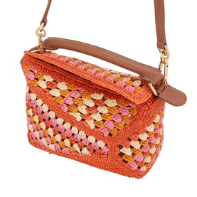 Loewe Puzzle Edge Crochet Mini Bag in bright orange and pink raffia with tan leather top handle, gold hardware, and adjustable crossbody strap