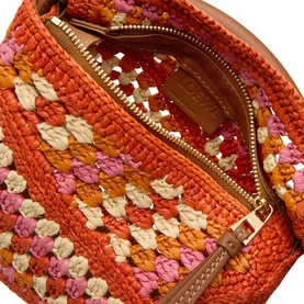 Loewe Puzzle Edge Crochet Mini Bag in bright orange and pink raffia, open zip showing tan leather lining and gold-tone hardware.