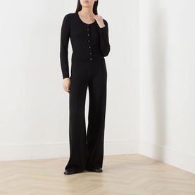 Model wearing Max Mara Studio black silk-wool cardigan with button front, styled with wide-leg black trousers.