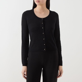 Model wearing Max Mara Studio black silk-wool cardigan with round neck, pearl buttons, and slim fit, styled with black trousers.
