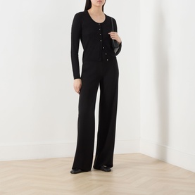 Model wearing Max Mara Studio black silk-wool cardigan with wide-leg trousers, styled with a dark shoulder bag and black shoes.