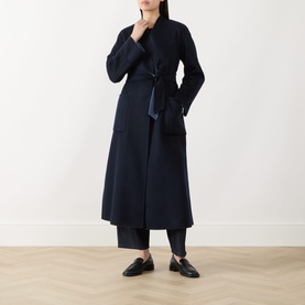 Model wearing Max Mara Studio navy bicolour wool coat with tie belt and patch pockets, styled with black wide-leg trousers and loafers
