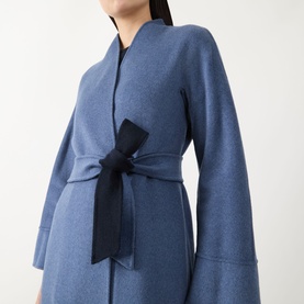 Model wearing Max Mara Studio navy bicolour wool coat with wide sleeves, collarless neckline, and contrasting dark tie belt.