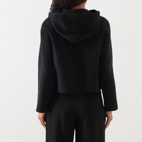 Model wearing Max Mara Studio black wool-silk-cashmere hooded cropped coat, back view, styled with black wide-leg trousers.