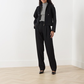 Model wearing Max Mara Studio black virgin wool, silk and cashmere coat with grey turtleneck, black wide-leg trousers and black heels.