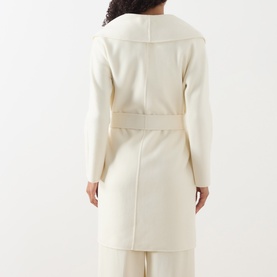 Model wearing Max Mara Studio white wool-silk-cashmere coat, rear view showing wide lapel collar and self-tie belt detail.