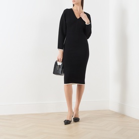 Model wearing Max Mara Studio black white knit midi dress with V-neck and 3/4 sleeves, styled with black mini bag and flat shoes