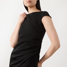 Model wearing Max Mara Studio black dress with cap sleeves, boat neckline and ruched side detail.