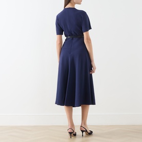 Model wearing Max Mara Studio navy midi dress, back view, short sleeves, flared skirt, with black belt and black heeled sandals