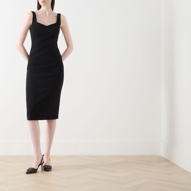 Model wearing Max Mara Studio Sala Sweetheart Dress in black, midi length with sweetheart neckline and spaghetti straps, styled with black flats.