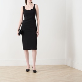 Model wearing Max Mara Studio Sala Sweetheart Dress in black, midi length with sweetheart neckline, styled with black clutch and black ballet flats.
