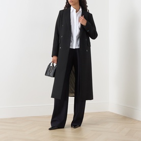 Model wearing Max Mara Studio Staffa Broderie Anglaise Shirt in Optical White, styled with a long black coat and wide-leg trousers.