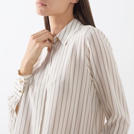 Model wearing Max Mara Studio silk shirt in Natural Stripe, close-up of collar and button placket detail with long sleeves visible.
