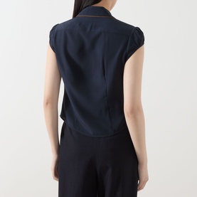 Model wearing Max Mara Studio Midnight Blue silk shirt, back view, cap sleeves and centre back seam detail, styled with navy trousers