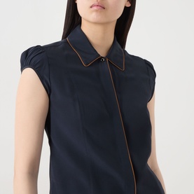 Model wearing Max Mara Studio midnight blue silk shirt with contrast piping trim detail and cap sleeves, close-up view