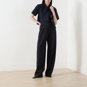 Model wearing Max Mara Studio Midnight Blue silk shirt with matching wide-leg trousers and black shoes.