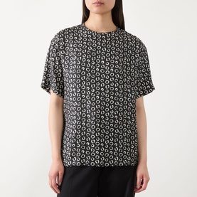 Model wearing Max Mara Studio Mambo Printed Blouse in black and white silk, featuring round neckline, short sleeves and allover circle print.
