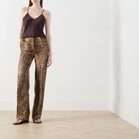 Model wearing Max Mara Studio Comma Cami Top in chocolate, styled with gold leopard-print sequin wide-leg trousers and flat sandals.