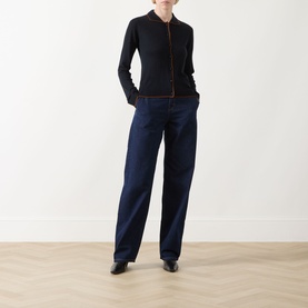 Model wearing dark navy wide-leg jeans with a black zip-up knit top and black leather shoes