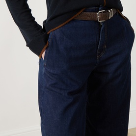 Model wearing dark indigo wide-leg jeans with brown leather belt, styled with a black long-sleeve top.