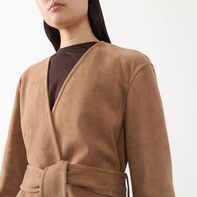 Model wearing Max Mara Studio camel lamb leather belted trench coat with V-neckline, styled over a dark brown top.