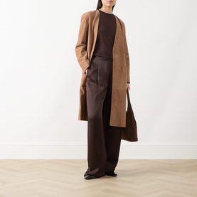 Model wearing Max Mara Studio camel lamb leather trench coat, styled with dark brown top and wide-leg trousers.