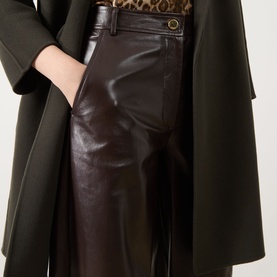 Model wearing Max Mara Studio brown faux leather trousers with a leopard print top and dark green coat.