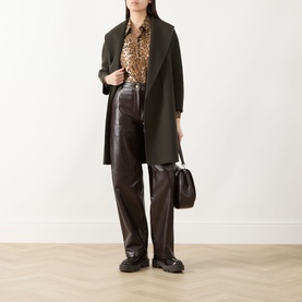 Model wearing Max Mara Studio brown wide-leg faux leather trousers, styled with dark coat, leopard print shirt and black chunky loafers.