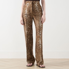 Model wearing Max Mara Studio Romana Leopard Straight Leg Trousers in brown spotted silk-twill, styled with strappy heeled sandals.