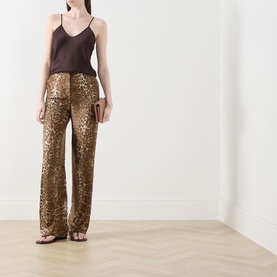 Model wearing Max Mara Studio Romana Leopard Straight Leg Trousers in brown spotted silk-twill, styled with a dark camisole and flat sandals.