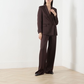 Model wearing Max Mara Studio Chocolate wide-leg trousers styled with a matching chocolate double-breasted blazer and black shoes.