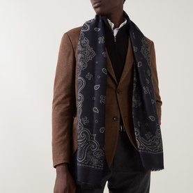 Model with Salvatore Ferragamo Arabesque Paisley Scarf in navy, featuring paisley motif and frayed trim, styled over a brown blazer